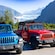 A 4 door off road vehicle parked next to a 2 door one with Mendenhall Glacier in the distance